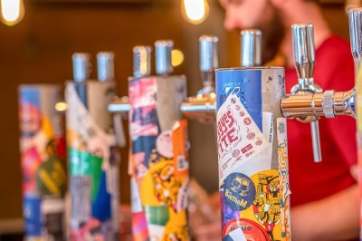 Miniature Location salle Nantes (Loire-Atlantique) - Les Berthom Nantes #15 Logo ’Les Berthom’ noir sur un tissu rouge avec un motif de main formant un signe de paix dans la lettre ’M’.