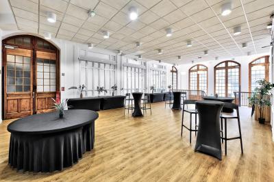 Vue intérieure d'une église avec des bancs en bois, des vitraux colorés et une architecture voûtée.