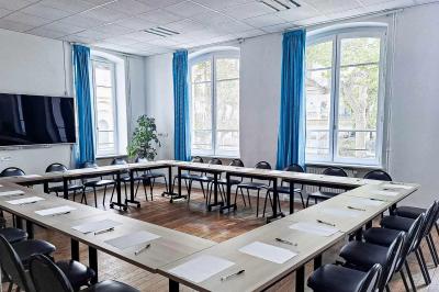 Vue intérieure d'une église avec des bancs en bois, des vitraux colorés et une architecture voûtée.