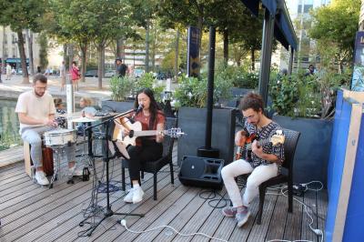Terrasse bondée d'un restaurant au bord d'un canal, avec des convives profitant de la soirée.