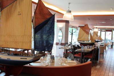 Terrasse bondée d'un restaurant au bord d'un canal, avec des convives profitant de la soirée.