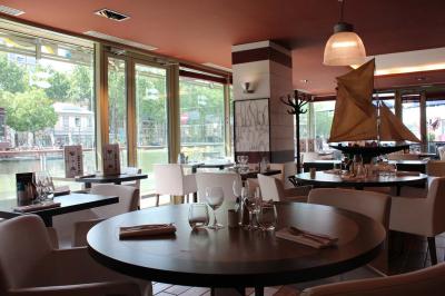 Terrasse bondée d'un restaurant au bord d'un canal, avec des convives profitant de la soirée.