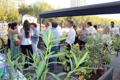 Des personnes dînent en terrasse au bord d'un canal, près d'un restaurant éclairé en soirée.