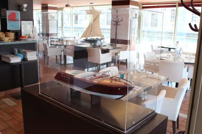 Des personnes dînent en terrasse au bord d'un canal, près d'un restaurant éclairé en soirée.