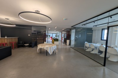 Miniature Location salle Seclin (Nord) - Luminaria #100 Salle moderne avec tables hautes blanches, éclairage coloré et murs vitrés, prête pour un événement.