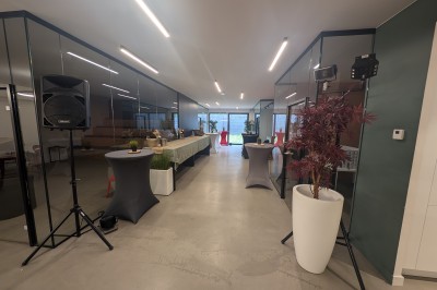 Miniature Location salle Seclin (Nord) - Luminaria #105 Salle moderne avec tables hautes blanches, éclairage coloré et murs vitrés, prête pour un événement.