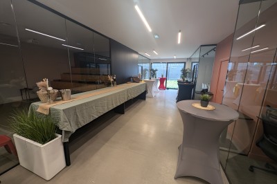 Miniature Location salle Seclin (Nord) - Luminaria #106 Salle moderne avec tables hautes blanches, éclairage coloré et murs vitrés, prête pour un événement.