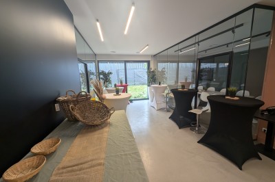 Miniature Location salle Seclin (Nord) - Luminaria #107 Salle moderne avec tables hautes blanches, éclairage coloré et murs vitrés, prête pour un événement.