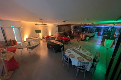 Miniature Location salle Seclin (Nord) - Luminaria #108 Salle moderne avec tables hautes blanches, éclairage coloré et murs vitrés, prête pour un événement.