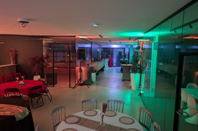 Miniature Location salle Seclin (Nord) - Luminaria #110 Salle moderne avec tables hautes blanches, éclairage coloré et murs vitrés, prête pour un événement.
