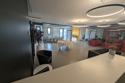 Miniature Location salle Seclin (Nord) - Luminaria #104 Salle moderne avec tables hautes blanches, éclairage coloré et murs vitrés, prête pour un événement.