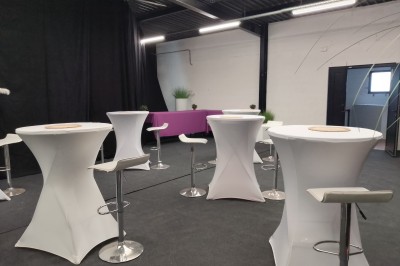 Miniature Location salle Seclin (Nord) - Luminaria #8 Salle moderne avec tables hautes blanches, éclairage coloré et murs vitrés, prête pour un événement.