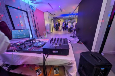 Un Père Noël décoratif près d'un sapin orné de boules argentées et de guirlandes rouges, dans un décor festif.