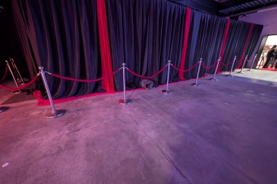 Un Père Noël décoratif près d'un sapin orné de boules argentées et de guirlandes rouges, dans un décor festif.