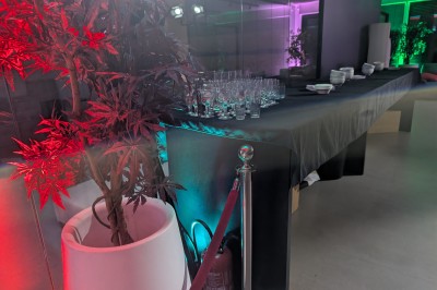 Un Père Noël décoratif près d'un sapin orné de boules argentées et de guirlandes rouges, dans un décor festif.