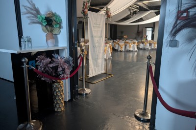 Un Père Noël décoratif près d'un sapin orné de boules argentées et de guirlandes rouges, dans un décor festif.