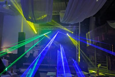 Un grand groupe de jeunes assis dehors sur un sol en béton, près de bâtiments sous un ciel nuageux.