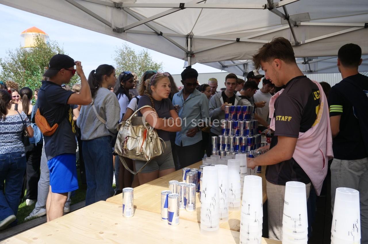 Des personnes font la queue sous des tentes pour recevoir des boissons servies par des bénévoles lors d'un événement en…