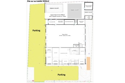 Un grand groupe de jeunes assis dehors sur un sol en béton, près de bâtiments sous un ciel nuageux.