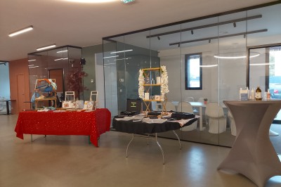 Un grand groupe de jeunes assis dehors sur un sol en béton, près de bâtiments sous un ciel nuageux.