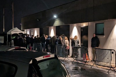 Miniature Location salle Seclin (Nord) - Luminaria #9 Un grand groupe de jeunes assis dehors sur un sol en béton, près de bâtiments sous un ciel nuageux.
