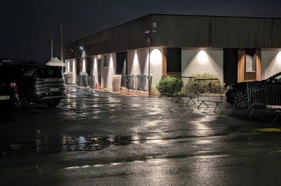 Miniature Location salle Seclin (Nord) - Luminaria #7 Un grand groupe de jeunes assis dehors sur un sol en béton, près de bâtiments sous un ciel nuageux.