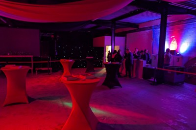 Miniature Location salle Seclin (Nord) - Luminaria #119 Un grand groupe de jeunes assis dehors sur un sol en béton, près de bâtiments sous un ciel nuageux.