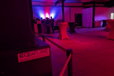 Miniature Location salle Seclin (Nord) - Luminaria #161 Un grand groupe de jeunes assis dehors sur un sol en béton, près de bâtiments sous un ciel nuageux.