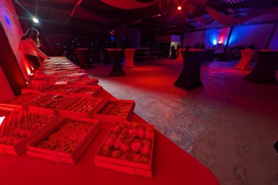 Miniature Location salle Seclin (Nord) - Luminaria #50 Un grand groupe de jeunes assis dehors sur un sol en béton, près de bâtiments sous un ciel nuageux.