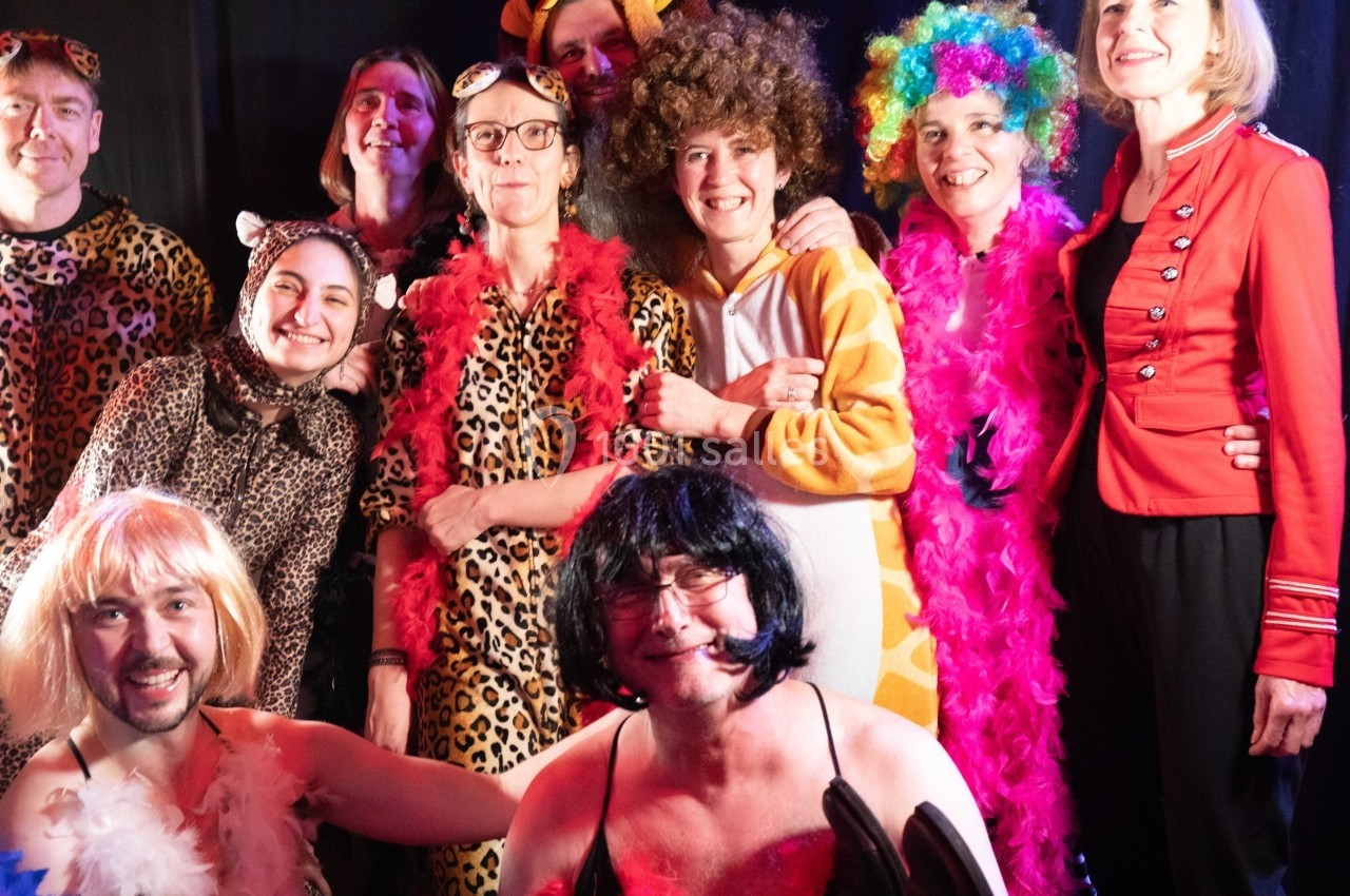 Un groupe de personnes déguisées en costumes colorés et variés, posant ensemble dans un cadre festif.