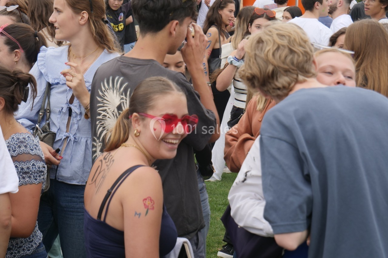 Groupe de personnes rassemblées en extérieur, certaines discutant et souriant dans une ambiance décontractée.