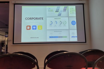 Des enfants colorient des dessins autour d'une table ronde, entourés d'adultes dans un espace intérieur animé.