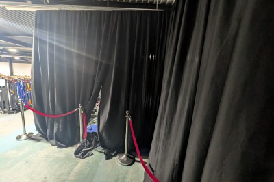 Des enfants colorient des dessins autour d'une table ronde, entourés d'adultes dans un espace intérieur animé.