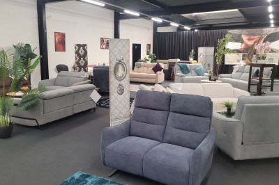 Des enfants colorient des dessins autour d'une table ronde, entourés d'adultes dans un espace intérieur animé.