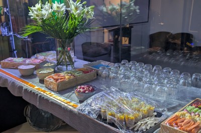 Deux mascottes en ours, blanc et rose, posent debout dans un espace intérieur animé avec des visiteurs.