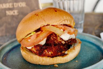 Salle de réunion moderne avec tables disposées en U, chaises en bois, éclairage suspendu et écran mural.