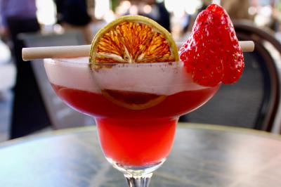 Salle de réunion moderne avec tables disposées en U, chaises en bois, éclairage suspendu et écran mural.