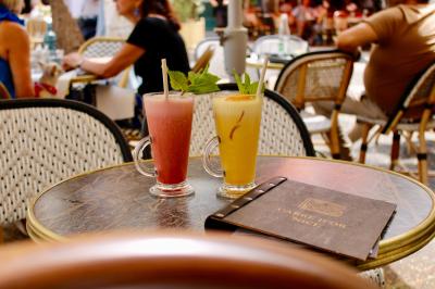 Salle de réunion moderne avec tables disposées en U, chaises en bois, éclairage suspendu et écran mural.