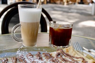 Salle de réunion moderne avec tables disposées en U, chaises en bois, éclairage suspendu et écran mural.