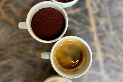 Salle de réunion moderne avec tables disposées en U, chaises en bois, éclairage suspendu et écran mural.