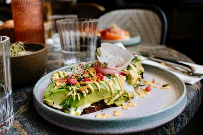 Deux verres de jus colorés sur une table en terrasse, l'un décoré de menthe et d'une tranche d'orange séchée.
