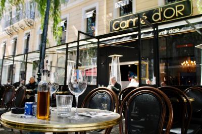 Deux verres de jus colorés sur une table en terrasse, l'un décoré de menthe et d'une tranche d'orange séchée.