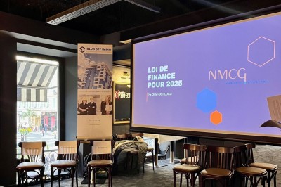 Deux verres de jus colorés sur une table en terrasse, l'un décoré de menthe et d'une tranche d'orange séchée.