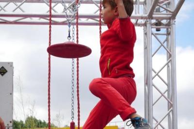 Deux acrobates exécutent une figure d'équilibre sur une caisse, devant un public dans un espace éclairé.