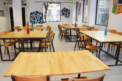 Salle de réunion avec une table rectangulaire, chaises noires, un tableau à feuilles mobiles et des décorations murales…