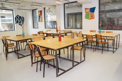 Salle de réunion avec une table rectangulaire, chaises noires, un tableau à feuilles mobiles et des décorations murales…