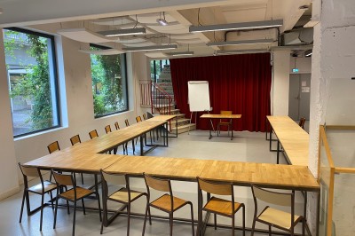 Salle de réunion avec une table rectangulaire, chaises noires, un tableau à feuilles mobiles et des décorations murales…
