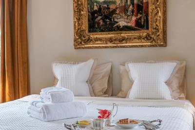Maison sur pilotis en bois entourée de verdure, située au bord d'un étang calme sous un ciel bleu.