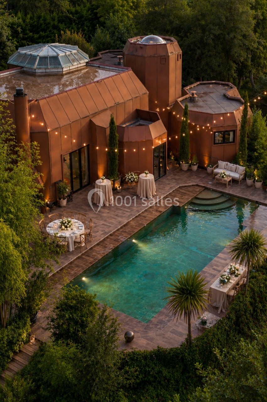 Maison en briques rouges avec piscine éclairée, entourée de végétation et décorée pour un événement en soirée.