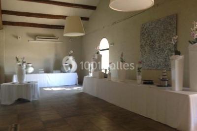 Vue aérienne d'un domaine rural avec bâtiments en pierre, arbres et vue sur une étendue d'eau calme en arrière-plan.